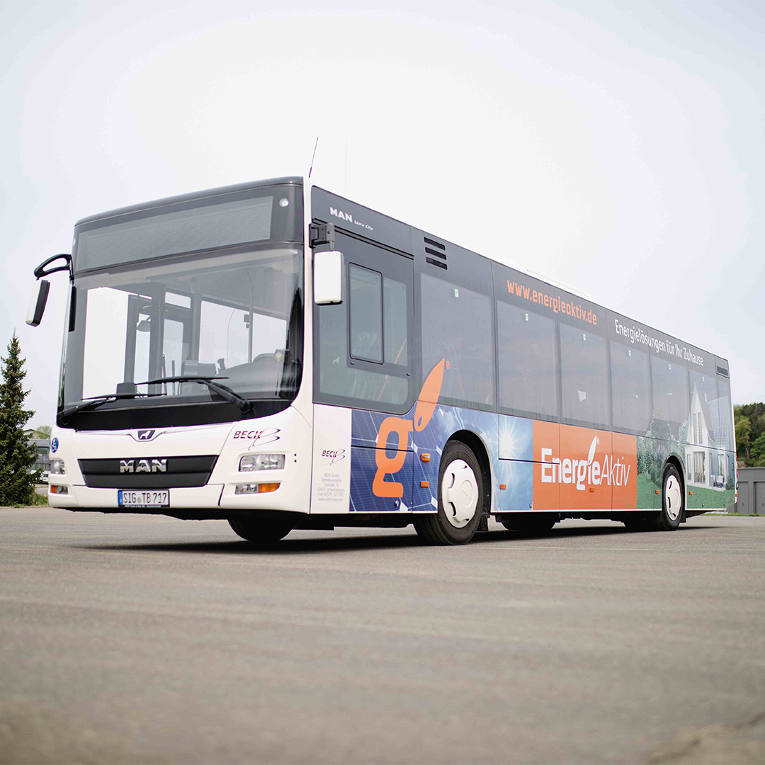 Bus steht seitlich und ist mit Buswerbung bedruckt.