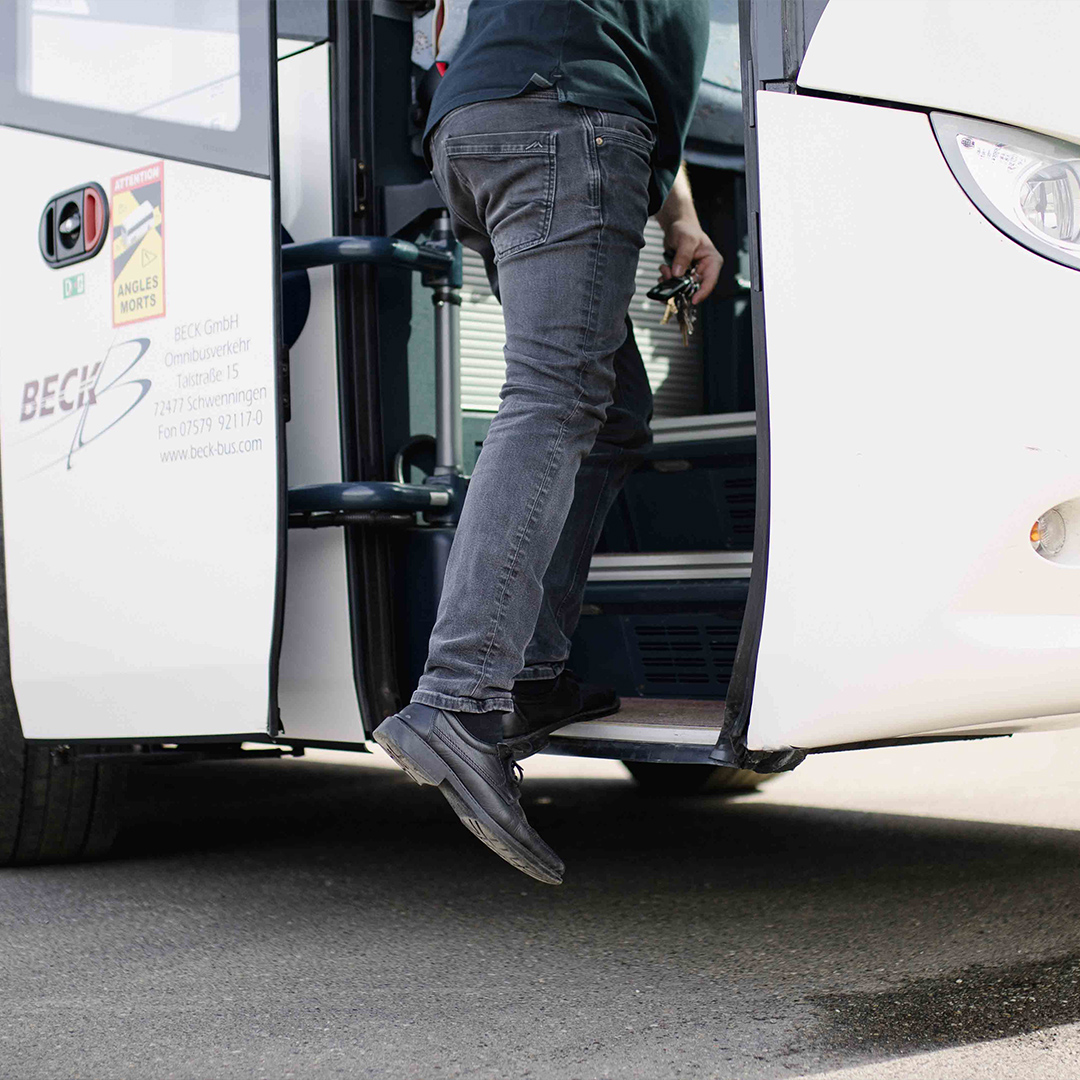 Mann steigt in den Bus ein.